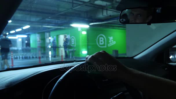 Primer plano de una mano humana en un tablero de instrumentos de un coche, mientras espera en un aparcamiento cerrado en un supermercado. 4k, cámara lenta — Vídeo de stock