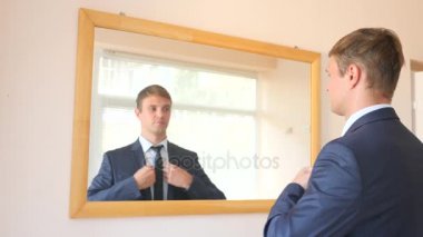 Neşeli bir sevimli adam gülümser ve bir ayna önünde onun yansıması Giydir. 4k, ağır çekim