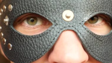yakın çekim deri siyah maske. yeşil gözleri ile maske bak. 4 k. ağır çekim