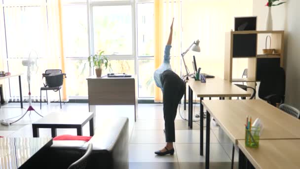 Женщина-руководитель, занимающаяся йогой на своем рабочем месте. 4k, slow motion — стоковое видео