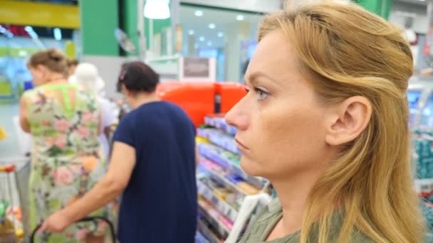 Очередь людей, стоящих у кассы в супермаркете. 4k, slow motion — стоковое видео