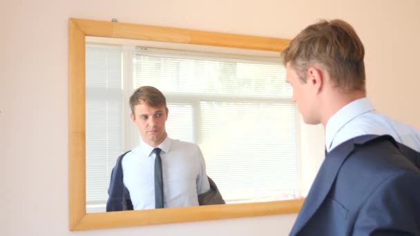 Müder unglücklicher Typ zieht sich vor einem Spiegel aus. 4k, Zeitlupe — Stockvideo