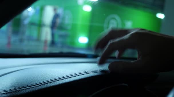 Close-up van een menselijke hand op een autodashboard, terwijl het wachten in een gesloten parking in een supermarkt. 4k, slow-motion — Stockvideo