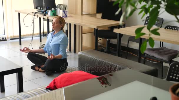 Female executive performing yoga at her workplace in office. 4k, slow motion