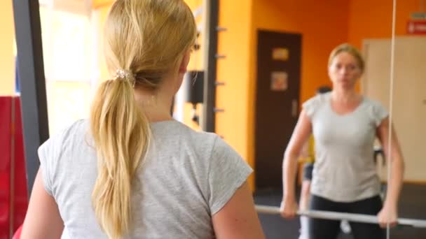 La mujer está ocupada en el gimnasio. 4k cámara lenta — Vídeos de Stock