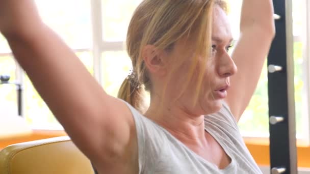 Женщина занимается в тренажерном зале. 4k slow motion — стоковое видео