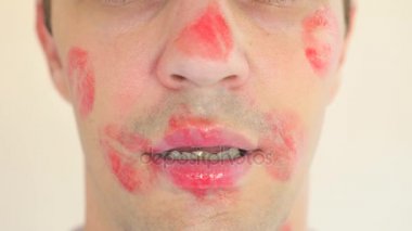 4 k. ağır çekim. Ruj yaka mans. genç bir adam portresi. onun bütün yüzü öpücük izleri ile kaplıdır. mutlu.