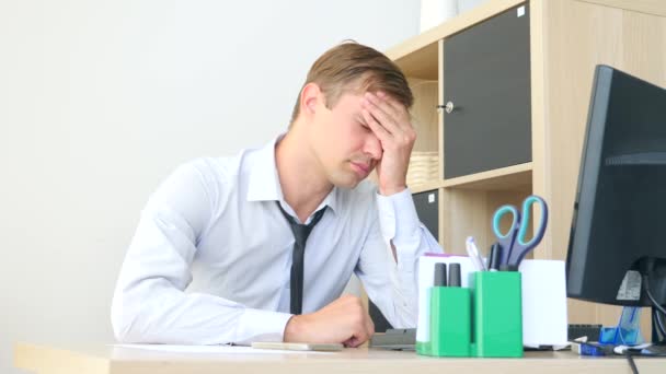 Een man die lijden aan pijn in haar hoofd terwijl u werkt op een computer. 4k, slow-motion — Stockvideo