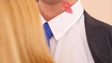 4 k. ağır çekim. Ruj yaka mans. sarışın bir kadın bir adam bir takım elbise ve beyaz bir gömlek öpüyor. Gömleğinde ruj izi bırakır.