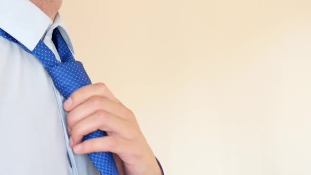 Um homem de negócios endireita uma gravata azul. 4K, câmera lenta, super close-up. espaço para cópia — Vídeo de Stock