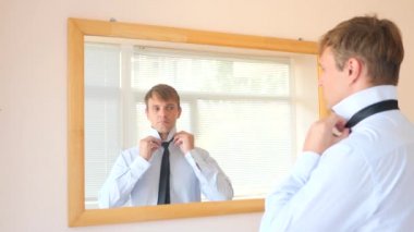 Neşeli bir sevimli adam gülümser ve bir ayna önünde onun yansıması Giydir. 4k, ağır çekim