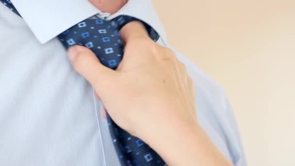 La mano femenina corrige sexualmente la corbata azul alrededor del cuello de un hombre de negocios. 4k, cámara lenta super primer plano — Vídeo de stock