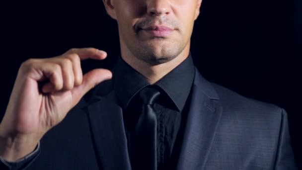 Super close-up van een man in de zwarte kleding op een zwarte achtergrond. 4 k. Slowmotion. — Stockvideo