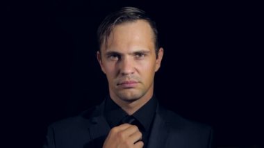 siyah bir arka plan üzerinde siyah giysili bir adam süper yakın çekim. 4 k. ağır çekim.