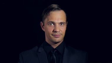 siyah bir arka plan üzerinde siyah giysili bir adam süper yakın çekim. 4 k. ağır çekim.