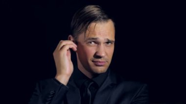 siyah bir arka plan üzerinde siyah giysili bir adam süper yakın çekim. 4 k. ağır çekim.