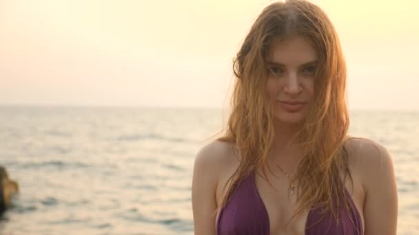 아름 다운 젊은 여자와 갈색 눈, 귀여운 미소 바다 파도의 배경에 카메라 보고. 4 k 슬로우 모션 — 비디오