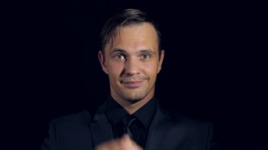 siyah bir arka plan üzerinde siyah giysili bir adam süper yakın çekim. 4 k. ağır çekim.