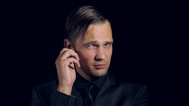 siyah bir arka plan üzerinde siyah giysili bir adam süper yakın çekim. 4 k. ağır çekim.