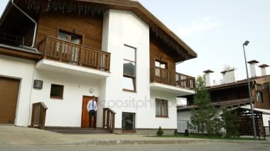 bir dağ evi, bir ev dağlarda bir arka plan üzerinde iş adamı. 4 k. sahiptir doğa görünümü