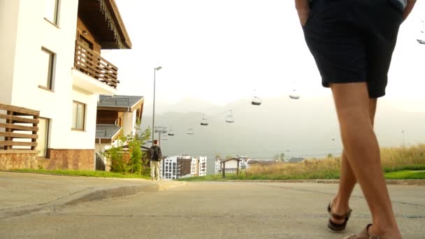 ビジネスの男性は、シャレー、山の中の家の背景に。4 k. は自然の眺めを楽しむ — ストック動画