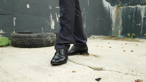 Mens klassiska svarta skor mot kollapsande väggen. affärsman promenader i en kollapsande byggnad. 4k. — Stockvideo