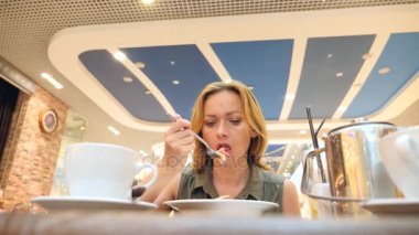 kadın diyet, yorgun bir kafede lahana salatası yemek. 4k, ağır çekim. kopya alanı