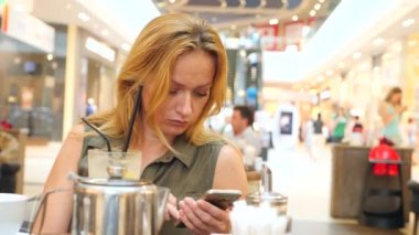 Birini kafede bekledi ve çay içme üzgün kadın. 4k, yavaş hareket, yakın çekim, kopya alanı