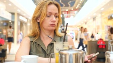 Birini kafede bekledi ve çay içme üzgün kadın. 4k, yavaş hareket, yakın çekim, kopya alanı