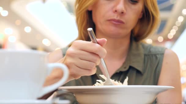 Femme épuisée par l'alimentation, mangeant de la salade de chou dans un café. 4k, au ralenti. espace de copie — Video