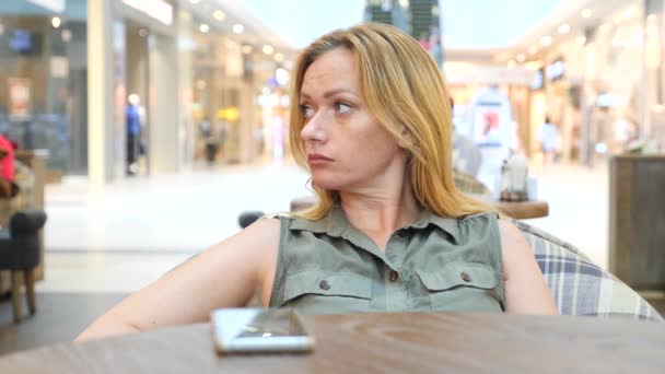 Uma mulher triste à espera de alguém no café e a beber chá. 4k, câmera lenta, close-up, espaço de cópia — Vídeo de Stock