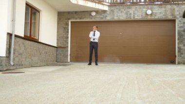 mutlu işadamı evinin kapısında duruyor. 4k