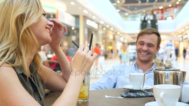 Casal no café. Homem e mulher bonita em um encontro estão rindo. 4K, câmara lenta, close-up. espaço de cópia — Vídeo de Stock
