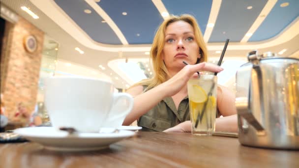 Triste mujer esperando a alguien en la cafetería y bebiendo té. 4k, cámara lenta, primer plano, espacio para copiar — Vídeos de Stock