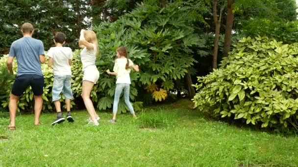 Boldog család együtt táncolni a fűben, egy gyönyörű természeti parkban. 4 k. másol hely. életmód — Stock videók