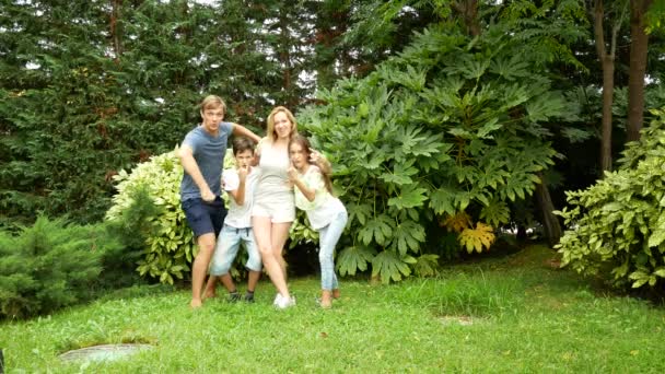 Boldog család együtt táncolni a fűben, egy gyönyörű természeti parkban. 4 k. másol hely. életmód — Stock videók