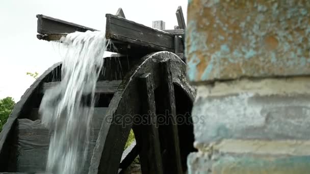 Een grote houten rad van een watermolen draait, het pompen van water. 4k. — Stockvideo