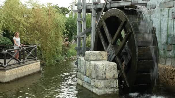 Een grote houten rad van een watermolen draait, het pompen van water. 4k. — Stockvideo