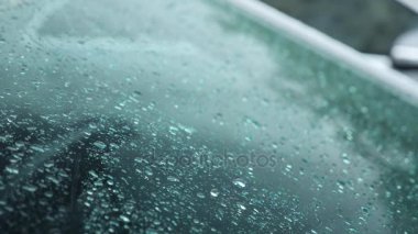 Dışarıda arabanın camına yağmur damlaları düşmek. 4k, yavaş hareket 4 k çekim,