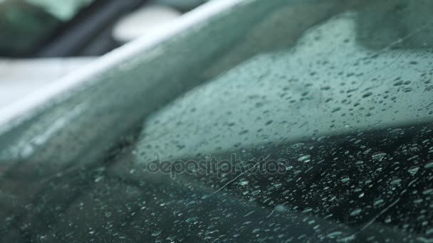 Gotas de lluvia caen sobre el cristal del coche estacionado fuera. 4k, grabación en cámara lenta 4k , — Vídeo de stock