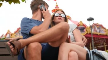 Mutlu aile Lunaparktaki bir bankta oturup ve eğlenin. 4 k yavaş hareket. kopya alanı. yaşam tarzı, Sochi Park, Eylül 2017