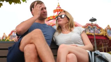 Mutlu aile Lunaparktaki bir bankta oturup ve eğlenin. 4 k yavaş hareket. kopya alanı. yaşam tarzı, Sochi Park, Eylül 2017