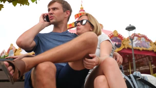 Gelukkige familie zitten op een bankje in een pretpark en plezier hebben. 4 k Slow-motion. Kopieer ruimte. leefstijl, Sochi Park, September 2017 — Stockvideo