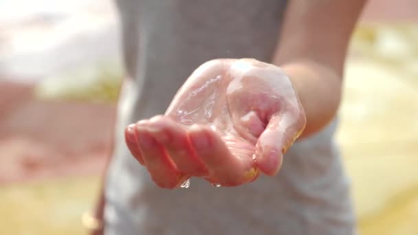 Womens hand omfattas i droppar av regn i närbild, 4k, slow motion — Stockvideo