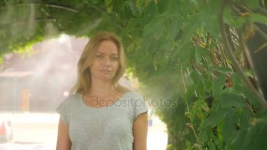 Ferahlatıcı duş bir tropik Bahçe Sulama tarafından genç kadının. Ağır çekim. 4k, kopya alanı