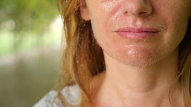 Retrato Mujer joven cuyo rostro está en gotitas de aguas poco profundas, disfrutando de una refrescante ducha de riego en un jardín tropical. En cámara lenta. 4k, espacio de copia — Vídeos de Stock