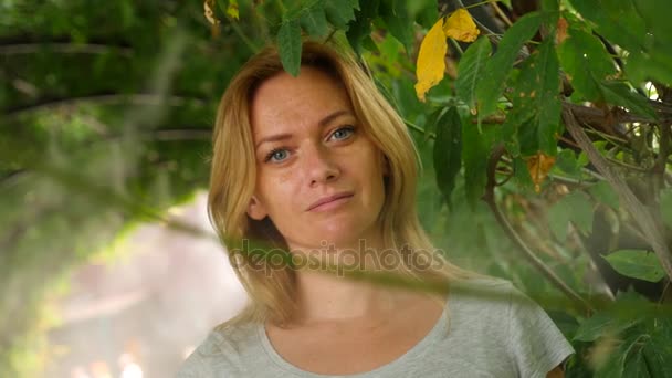 Mujer joven disfrutando de una refrescante ducha de riego en un jardín tropical. En cámara lenta. 4k, espacio de copia — Vídeos de Stock