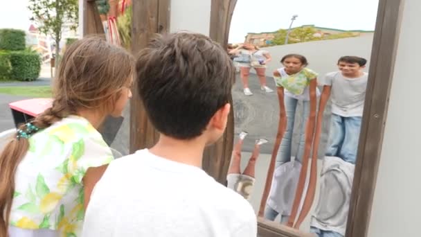 Mamá y sus hijos, gemelos chico y chica toma un reflejo en un espejo falso en la cámara. viaje estilo de vida. se ríen y tontean. 4k. Movimiento lento — Vídeos de Stock
