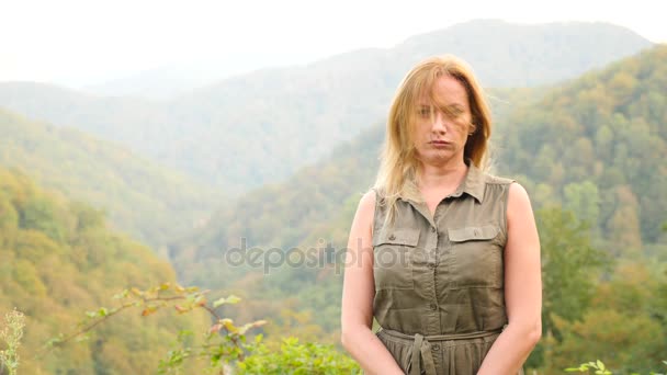 Bliska portret pięknej młodej kobiety z blond włosy wiejący wiatr, patrząc na góry. Zwolnionym tempie 4k — Wideo stockowe