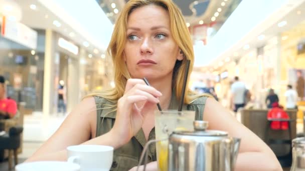 Triste mujer esperando a alguien en la cafetería y bebiendo té. 4k, cámara lenta, primer plano, espacio para copiar — Vídeos de Stock